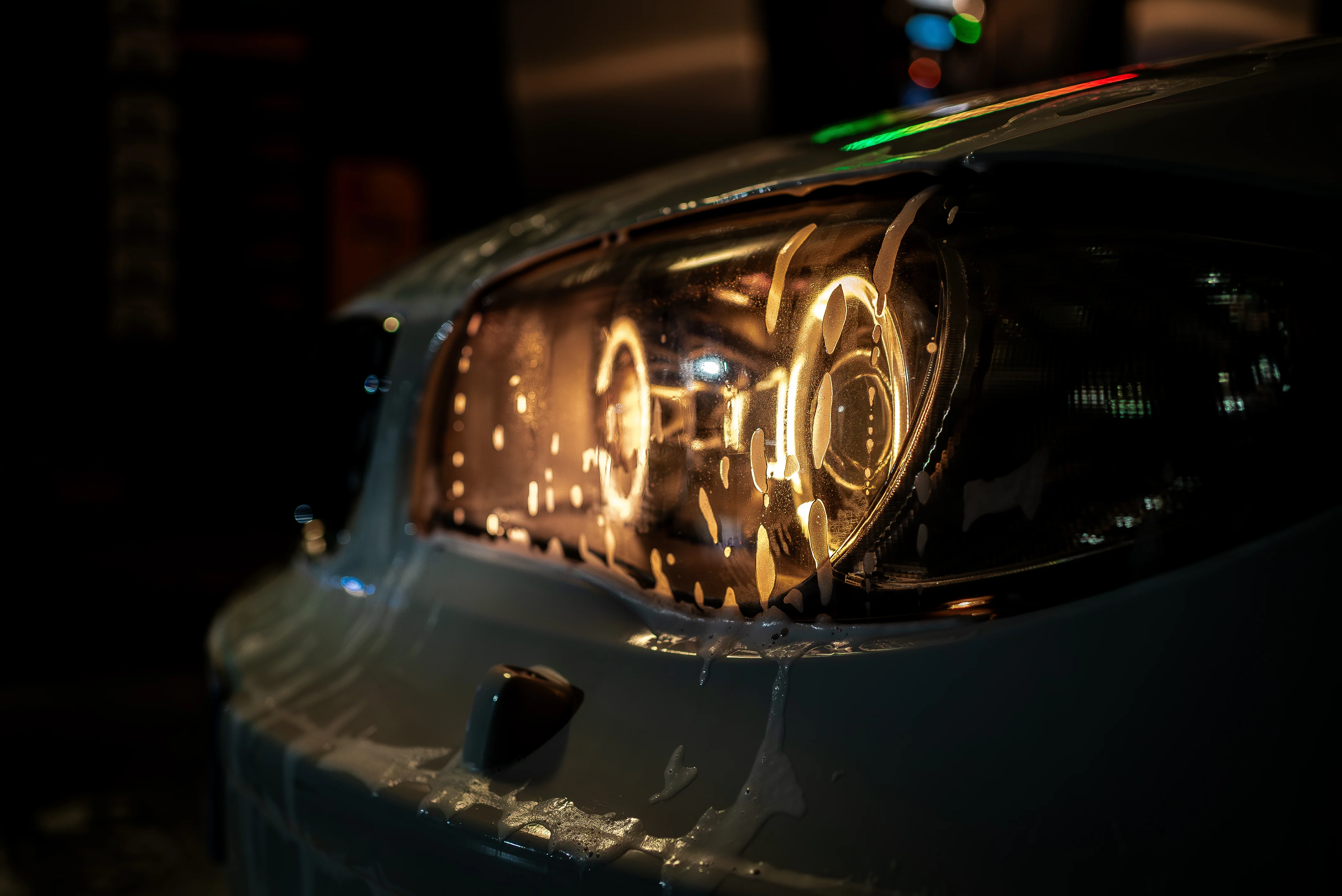 Optique BMW sous la mousse active lors d'un lavage detailing