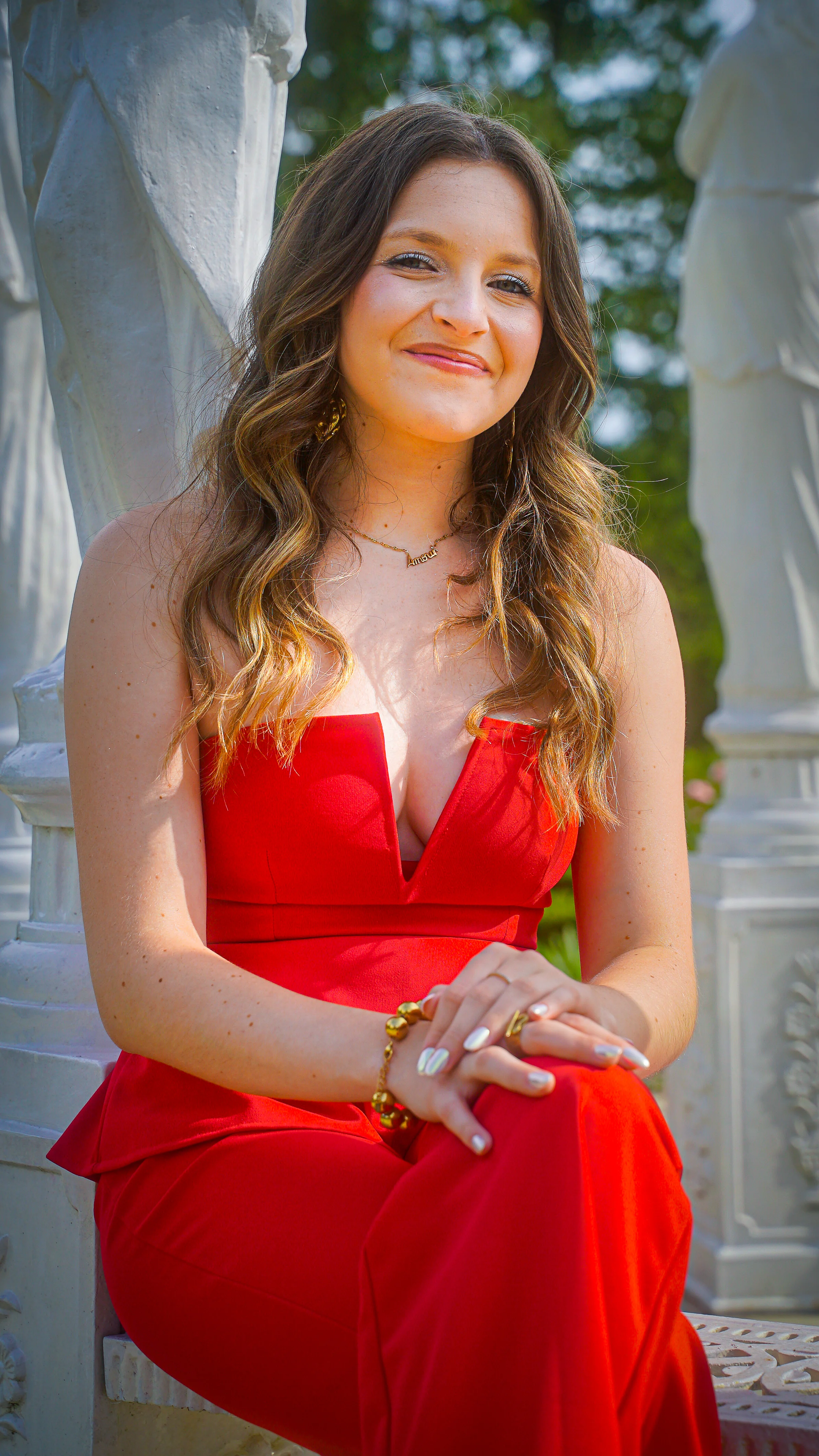 Shooting photo portrait élégant en combinaison rouge et statues